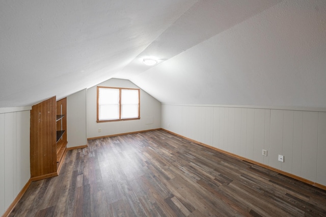 bonus room featuring wood finished floors and vaulted ceiling