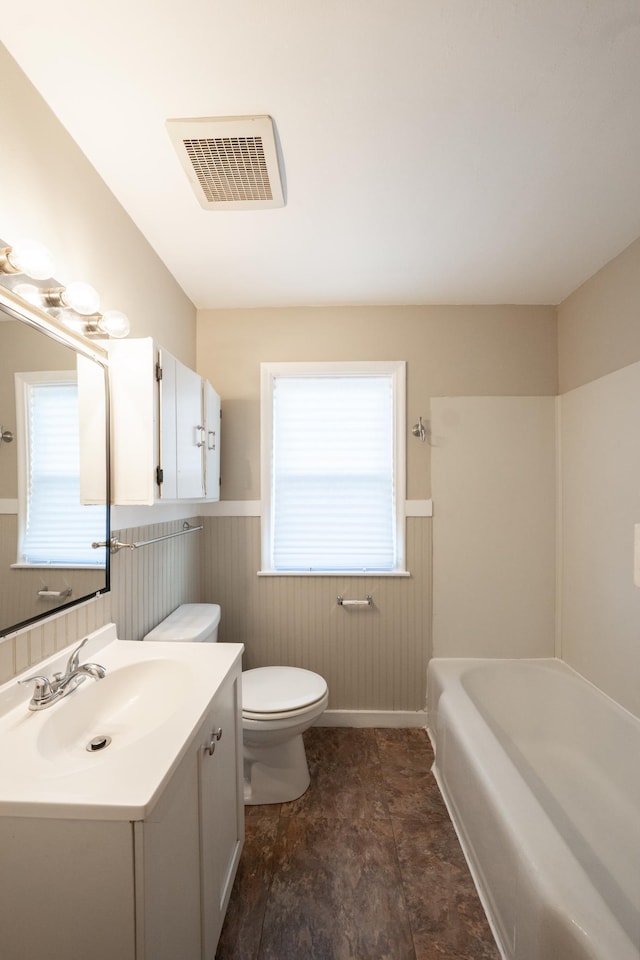 full bathroom with toilet, visible vents, a wealth of natural light, and wainscoting