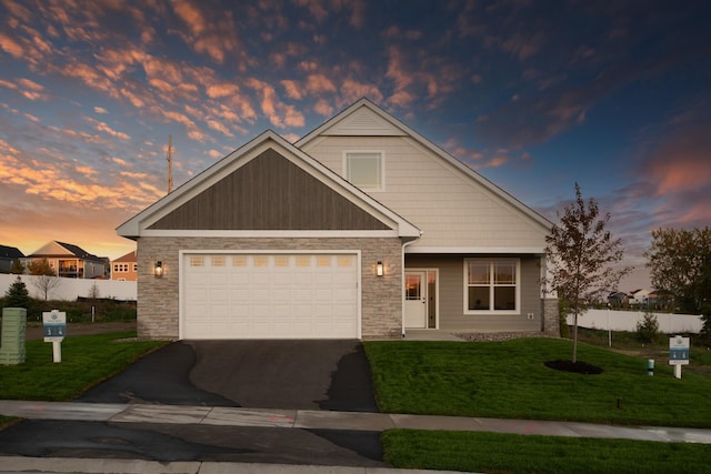 view of front of home with driveway, stone siding, fence, a yard, and a garage