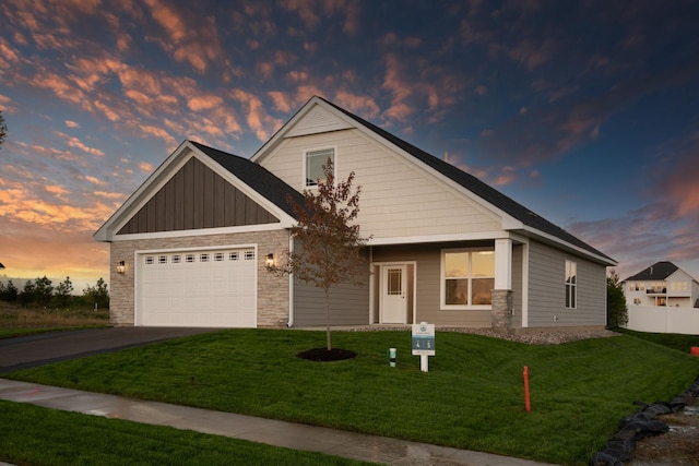 craftsman inspired home featuring a garage, a yard, board and batten siding, and driveway