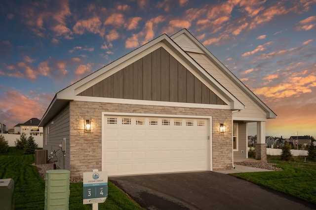 craftsman house featuring stone siding, an attached garage, board and batten siding, and driveway