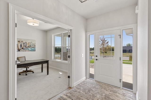 carpeted entryway featuring baseboards