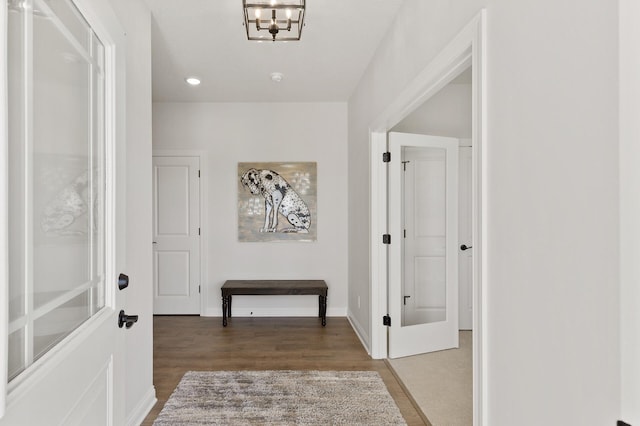 corridor featuring baseboards and wood finished floors