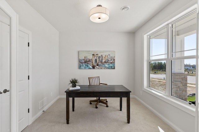 office space with light carpet, visible vents, and baseboards