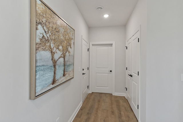 hall with baseboards and wood finished floors