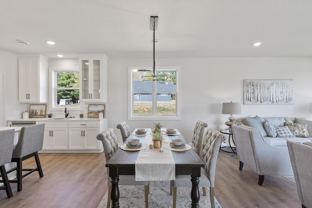 dining area with a chandelier, recessed lighting, and light wood-style flooring