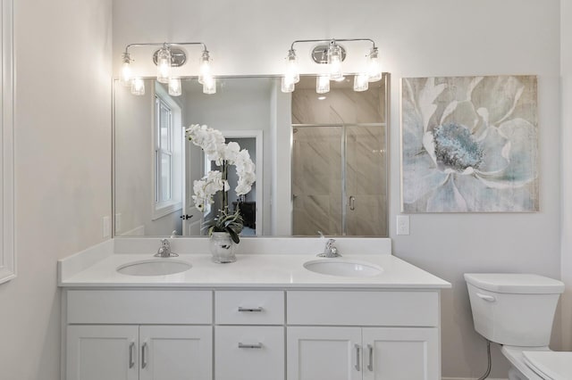 full bathroom with double vanity, a shower stall, toilet, and a sink