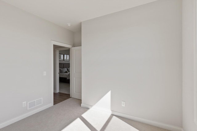 spare room with baseboards, visible vents, and carpet floors