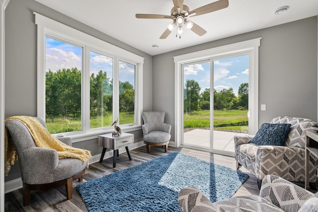 sitting room with wood finished floors, baseboards, and ceiling fan