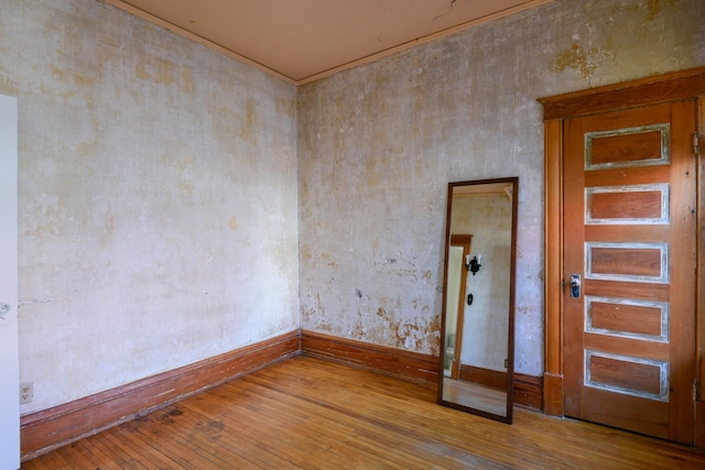 spare room featuring baseboards and hardwood / wood-style flooring