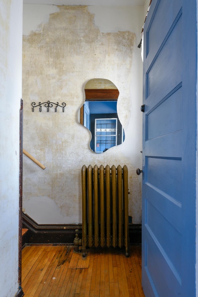 interior space with wood finished floors and radiator heating unit