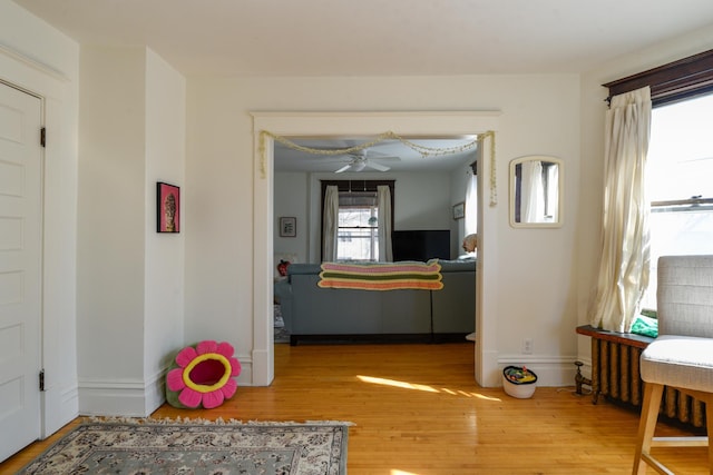 hall featuring wood finished floors and baseboards