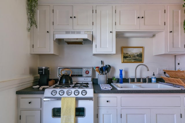 kitchen featuring dark countertops, under cabinet range hood, white gas range oven, white cabinetry, and a sink