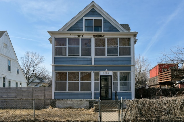 view of front facade featuring a fenced front yard, a gate, and a sunroom