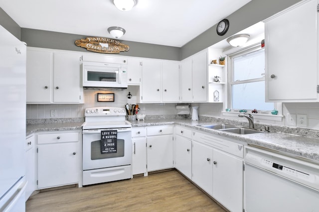 kitchen with decorative backsplash, white cabinets, white appliances, and a sink