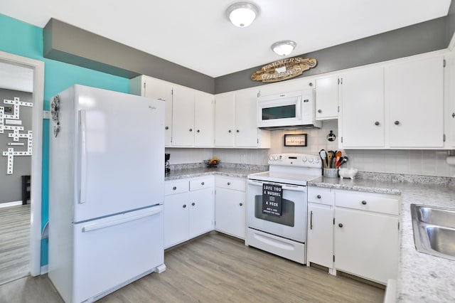 kitchen with decorative backsplash, white cabinets, white appliances, and light countertops