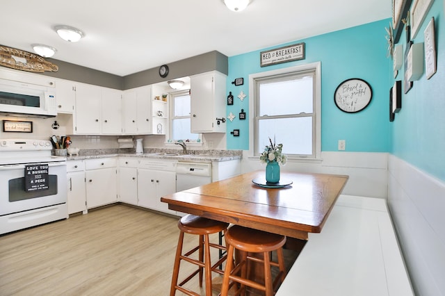 kitchen featuring light wood-type flooring, open shelves, white cabinetry, white appliances, and light countertops