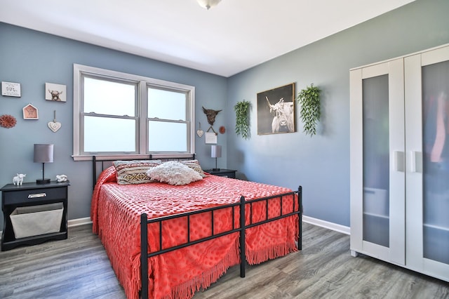 bedroom with baseboards and wood finished floors