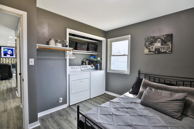 bedroom with wood finished floors, separate washer and dryer, and baseboards