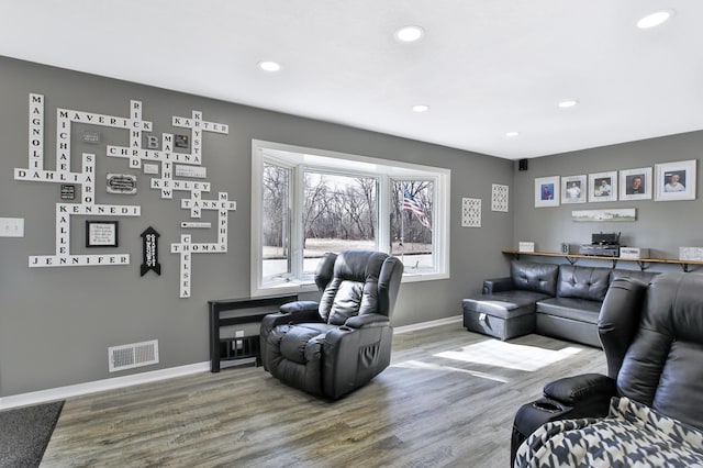 living area featuring visible vents, recessed lighting, baseboards, and wood finished floors