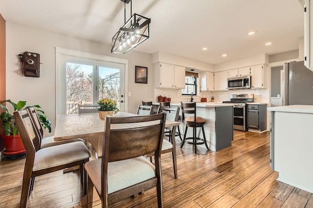 dining area with recessed lighting and light wood-style floors