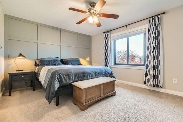 bedroom featuring light colored carpet, baseboards, and a ceiling fan