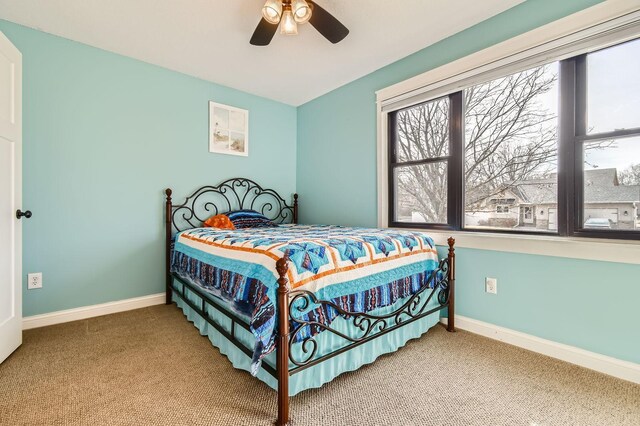 carpeted bedroom featuring ceiling fan and baseboards