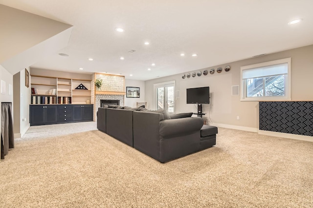 living area with light carpet, recessed lighting, and a tile fireplace