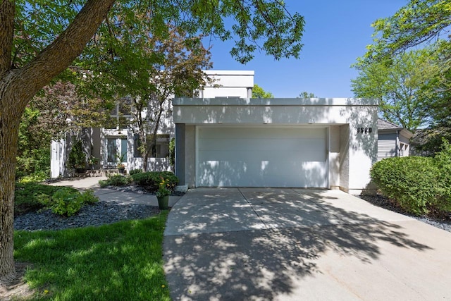 3520 Fairway Ln, Minnetonka, MN 55305 - view of front of house featuring an attached garage, concrete driveway, and stucco siding