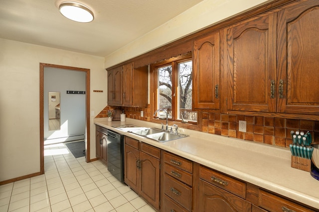 kitchen with light tile patterned floors, a sink, light countertops, black dishwasher, and backsplash