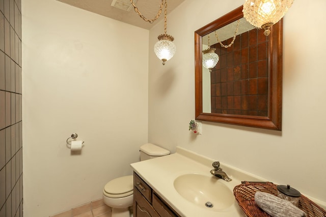 half bath with vanity, toilet, and tile patterned flooring