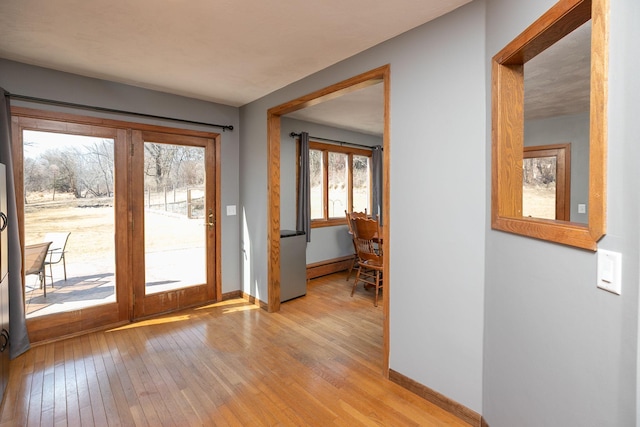 entrance foyer with light wood-type flooring, baseboards, and baseboard heating