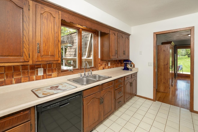 809 60th Ave SW, Rochester, MN 55902 - kitchen with dishwasher, a sink, light countertops, backsplash, and baseboards