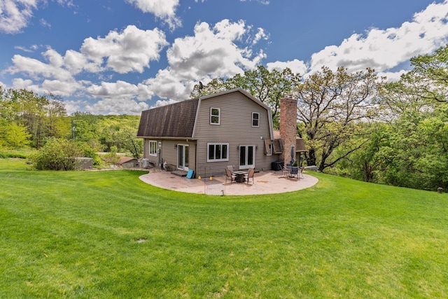 809 60th Ave SW, Rochester, MN 55902 - back of property featuring a gambrel roof, a lawn, a patio area, and a chimney