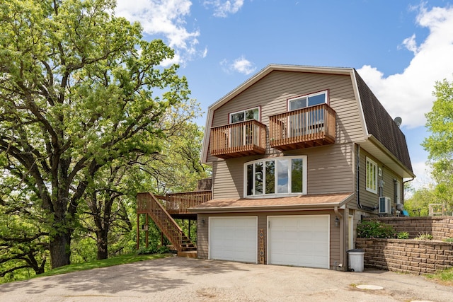 809 60th Ave SW, Rochester, MN 55902 - view of front of property with a balcony, a garage, asphalt driveway, stairway, and a gambrel roof