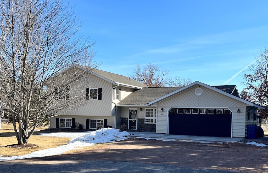 tri-level home featuring an attached garage and driveway