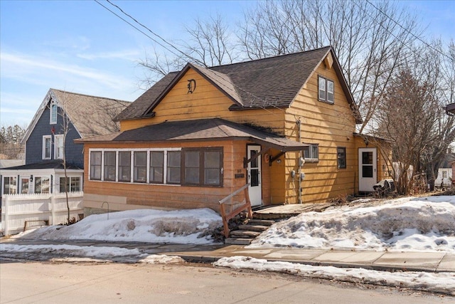 view of front of house with roof with shingles and fence