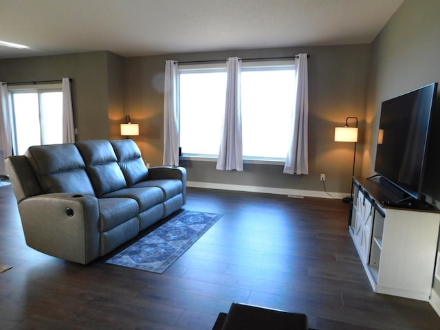 living area with baseboards and dark wood-style flooring