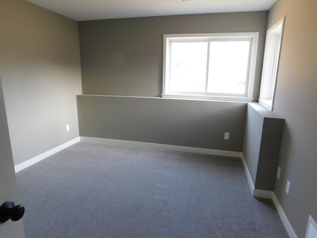 unfurnished room featuring baseboards and carpet