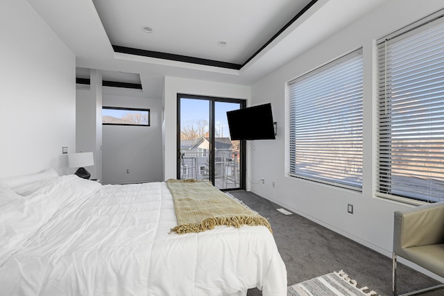 bedroom featuring baseboards, visible vents, access to exterior, a raised ceiling, and carpet flooring