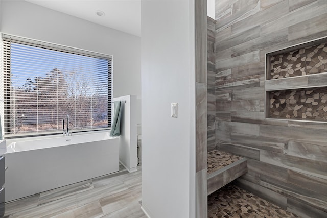 full bath featuring a soaking tub and tiled shower