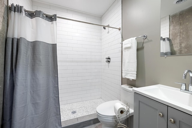 full bath with tiled shower, toilet, and vanity