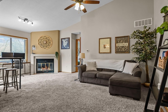 living area featuring visible vents, a fireplace with flush hearth, high vaulted ceiling, a ceiling fan, and carpet flooring