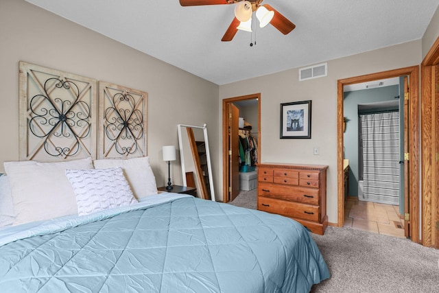 bedroom with visible vents, a walk in closet, ceiling fan, carpet floors, and a closet