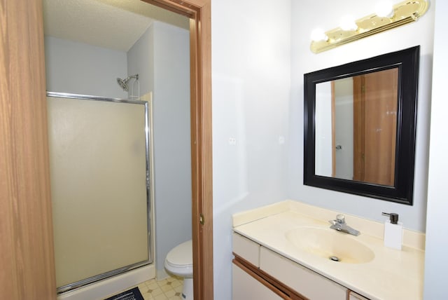 full bathroom with vanity, a stall shower, a textured ceiling, tile patterned floors, and toilet