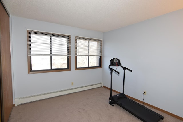 workout area with a baseboard heating unit, baseboards, carpet floors, and a textured ceiling