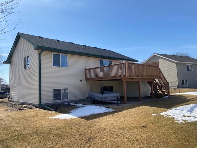 rear view of house featuring a lawn, stairs, and a deck