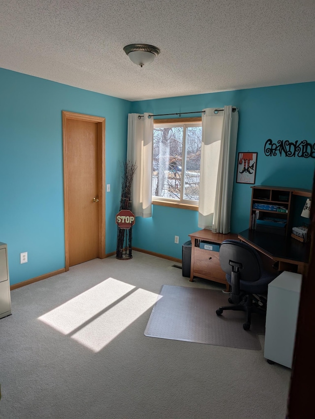 office space featuring carpet, baseboards, and a textured ceiling