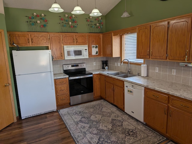 kitchen with white appliances, light countertops, brown cabinets, and a sink