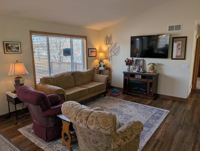 living room featuring visible vents, baseboards, and wood finished floors